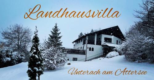 una foto di una casa nella neve di Die Landhausvilla in Unterach am Attersee a Unterach am Attersee