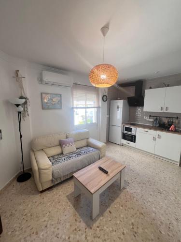uma sala de estar com um sofá e uma mesa em Apartamento El Faro em Barbate