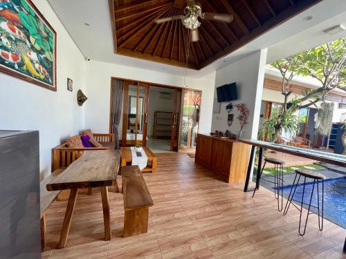 salon z drewnianym stołem i kanapą w obiekcie Bali Ayu Pool Villa w mieście Canggu