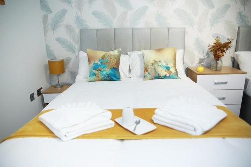 a bedroom with a white bed with towels on it at Superb Stonewall Terrace in London