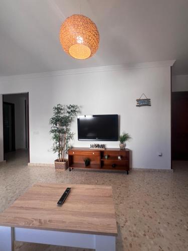 uma sala de estar com uma televisão de ecrã plano na parede em Apartamento El Faro em Barbate