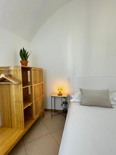 ein Schlafzimmer mit einem Bett und einem Tisch mit einer Lampe in der Unterkunft BordiLand 1 in Bordighera