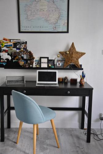 uma secretária com um computador portátil e uma cadeira azul em Cocon en centre-ville em Brest