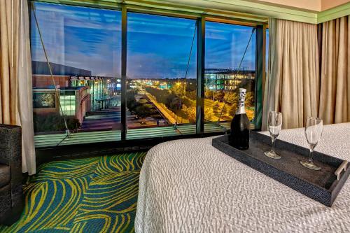 a room with a bed with wine glasses and a large window at SpringHill Suites Norfolk Old Dominion University in Norfolk