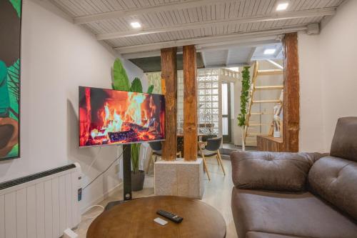 sala de estar con sofá y TV en la pared en Apartamentos Malasaña, en Madrid