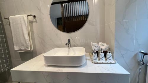 bagno con lavandino bianco e specchio di Khoáng nóng Wyndham Thanh Thủy a La Phu