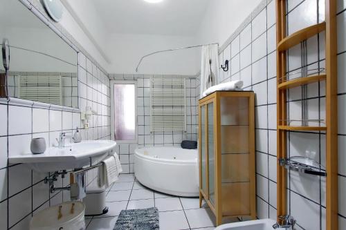 a white bathroom with a tub and a sink at Beautiful apartment with amazing Rooftop&Jacuzzi in Rome