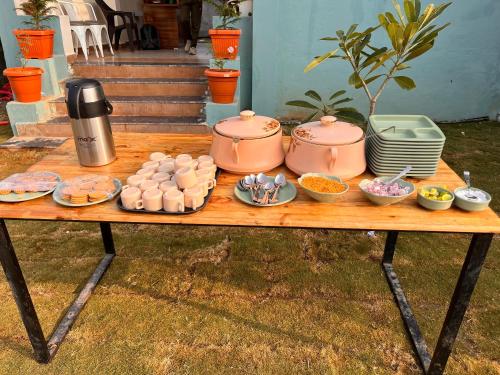 a table with pots and plates of food on it at House Of Ubuntu in Rāmtek