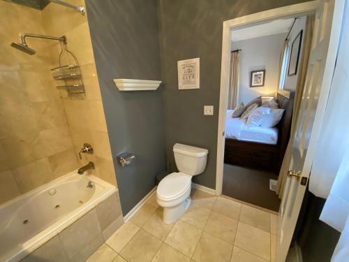 a bathroom with a toilet and a tub and a bed at Hidden East Village Gem in Chicago