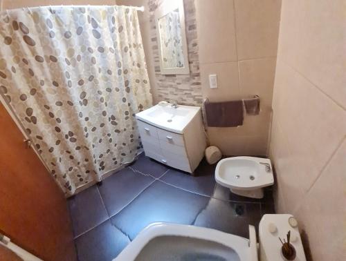 uma casa de banho com uma banheira, um WC e um lavatório. em Casa 6 pers. em Mendoza