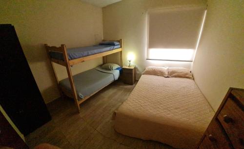 um quarto com 2 beliches e uma janela em Casa 6 pers. em Mendoza