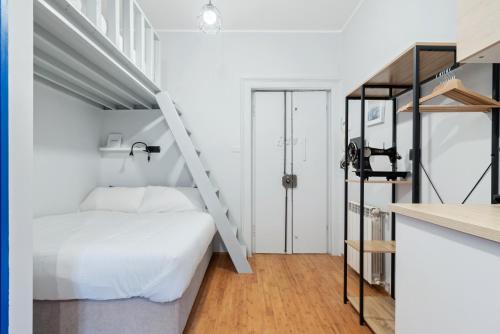 - une chambre avec un lit blanc et un escalier dans l'établissement Remy Studio - Design District, à Milan