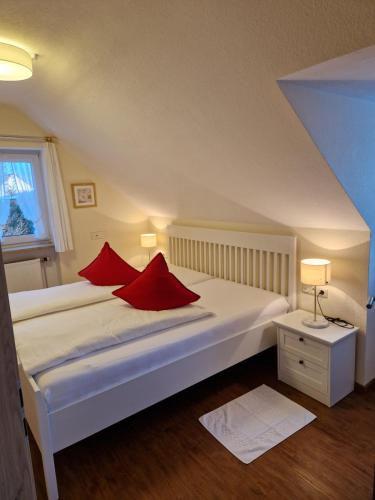 a bedroom with a bed with red pillows on it at Haus am Mühlenweg IV - sonnige und moderne Ferienappartements in Bad Wörishofen
