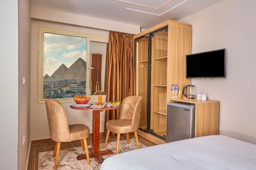 a hotel room with a table and chairs and a window at Rotana Pyramids View in Cairo