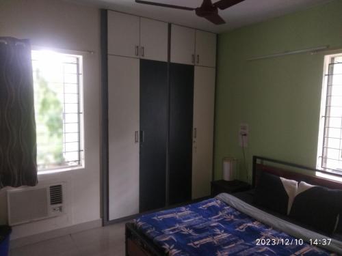 Royale Seaward Comfort Suites في تشيناي: غرفة نوم بجدران خضراء وسرير ونوافذ