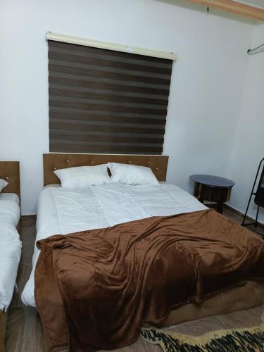 um quarto com uma cama grande e uma janela grande em Jerash Ruins Hotel em Gérasa