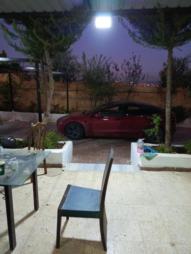 um carro estacionado num parque de estacionamento com uma mesa e cadeiras em Jerash Ruins Hotel em Gérasa