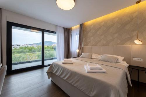 um quarto com uma cama grande e uma janela grande em Luxury Villa Miamore em Kaštela