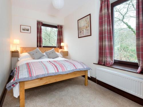 a bedroom with a bed and two windows at 3 Bed in Eskdale SZ502 in Eskdale