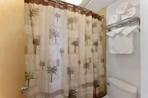 a bathroom with a shower curtain with palm trees at Waikiki Oceanfront Inn in Wildwood Crest