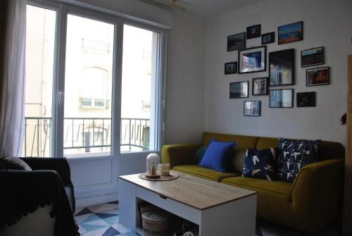 a living room with a couch and a table at Cocon en centre-ville in Brest