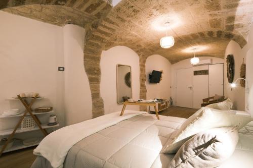 une chambre avec un grand lit avec un mur en pierre dans l'établissement Mary House, à Bari