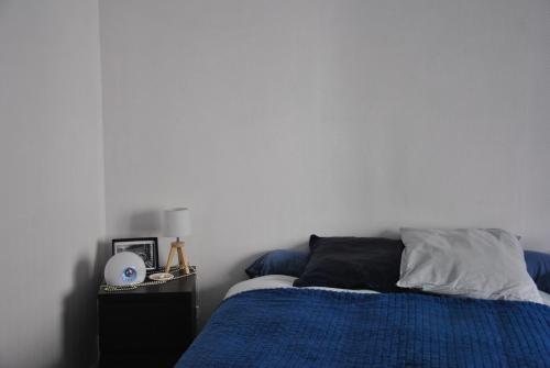 a bedroom with a bed with a blue comforter at Cocon en centre-ville in Brest