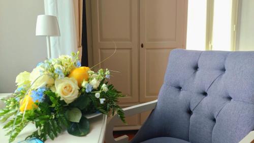 a bouquet of flowers on a desk next to a chair at Hotel La Rondinella in Cannero Riviera