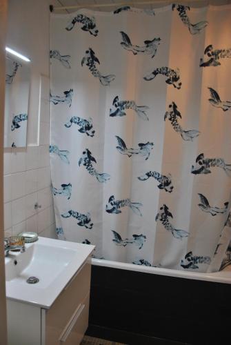 a bathroom with a shower curtain with fish on it at Cocon en centre-ville in Brest