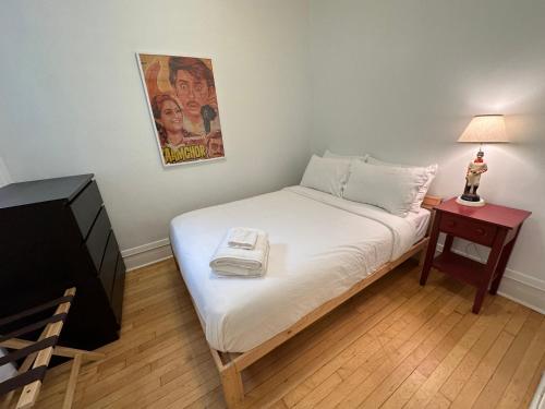 a small bedroom with a bed with a phone on it at Logan Square Hideaway in Chicago