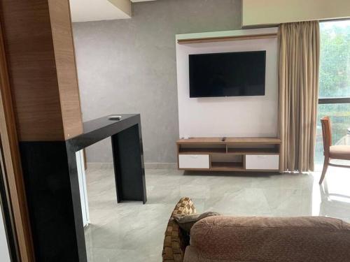 a living room with a flat screen tv on a wall at Flat em Tropical executive Hotel in Manaus