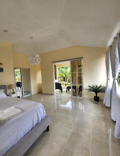 a large bedroom with a bed and a large room with at Villa sol de samana' in Los Róbalos