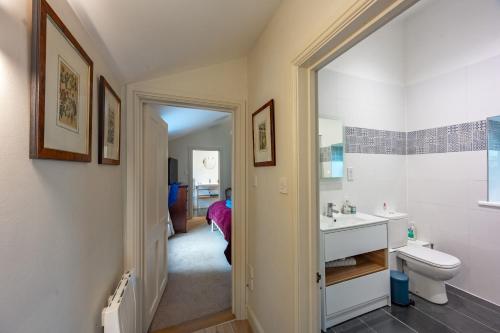 a white bathroom with a sink and a toilet at The Pottage in Hoxne