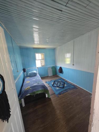 Zimmer mit einem Bett in einem blauen Zimmer in der Unterkunft Casa inteira Balneário Rincão in Balneário Rincão