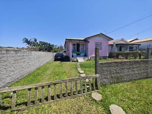 eine Holzbank vor einem Haus in der Unterkunft Casa inteira Balneário Rincão in Balneário Rincão