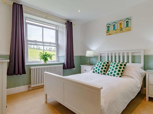 a bedroom with a white bed and a window at 4 Bed in Looe 82662 in Lanreath