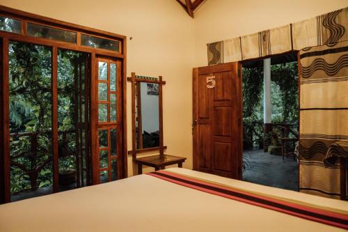 a bedroom with a bed and sliding glass doors at Aloe Vera Guest House in Dambulla
