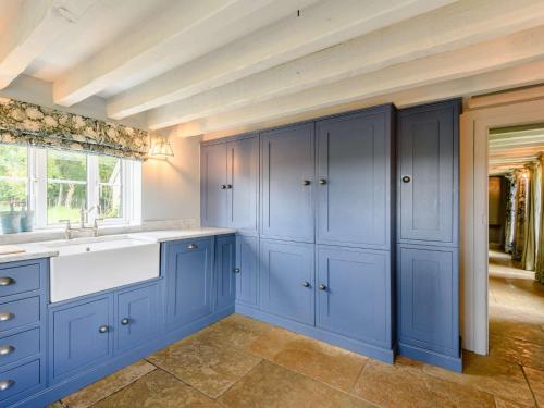 a kitchen with blue cabinets and a sink at 4 Bed in Redlynch 82799 in Winchester