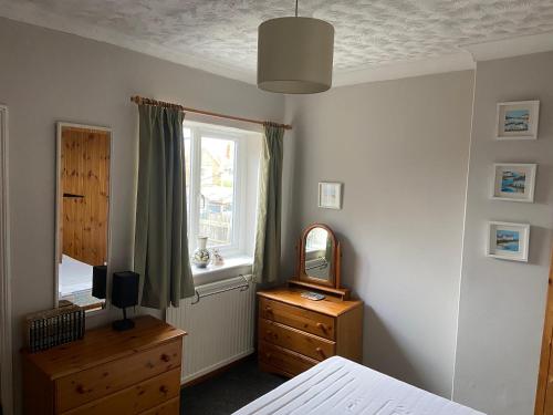 a bedroom with a bed and a mirror and a dresser at York Cottage a period character 2 bedroom cottage in Snettisham