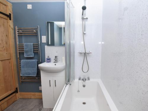 a bathroom with a tub and a sink and a shower at 1 bed in Crickhowell 82777 in Crickhowell