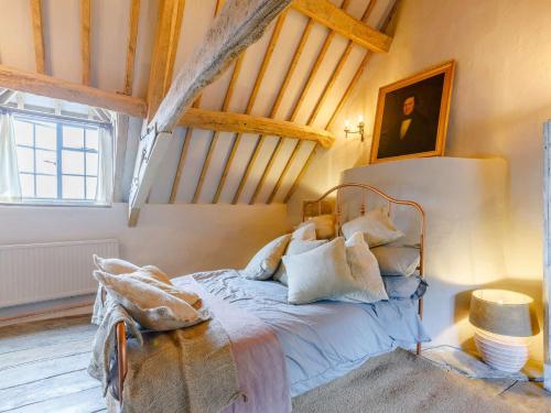 1 Bed in Longborough 82284 في Longborough: غرفة نوم بسرير في غرفة بسقوف خشبية