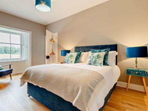 a bedroom with a large bed with a blue headboard at 1 Bed in Crieff 85244 in Crieff