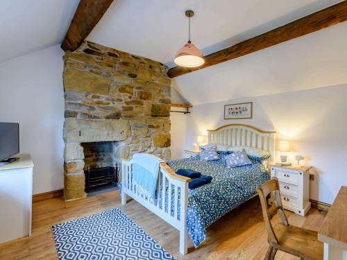 a bedroom with a bed and a stone fireplace at 3 Bed in Gwynfryn 83938 in Coedpoeth