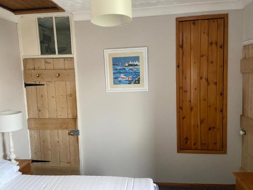 a bedroom with a bed and a wooden door at York Cottage a period character 2 bedroom cottage in Snettisham