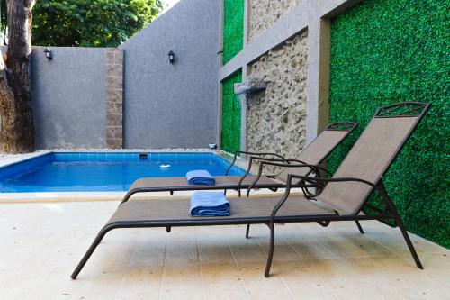 2 sillas sentadas junto a una piscina en Hotel El Marqués De Manga en Cartagena de Indias