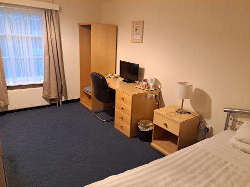 a bedroom with a desk with a computer and a bed at Luther King House in Manchester