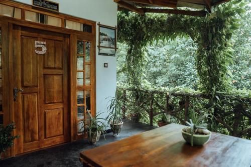 a room with a wooden door and a table with plants at Aloe Vera Guest House in Dambulla