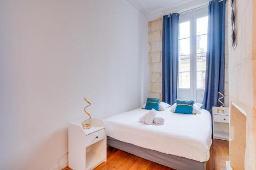 une chambre avec deux lits et une fenêtre dans l'établissement Le Bon Pasteur - Joli T2 Place de la Victoire, à Bordeaux