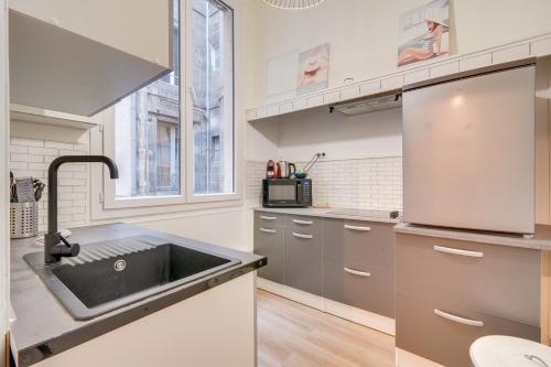 une cuisine avec un évier et une fenêtre dans l'établissement Le Bon Pasteur - Joli T2 Place de la Victoire, à Bordeaux