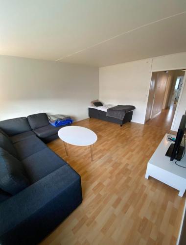 a living room with a black couch and a table at lovely apartment in Gothenburg in Gothenburg